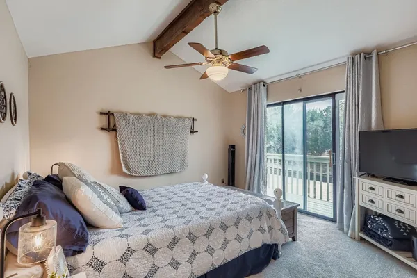 a bedroom with a bed television and a window