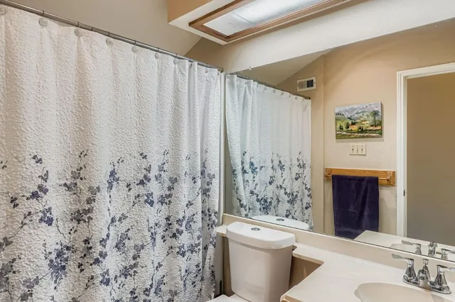 a bathroom with a toilet and a shower curtain