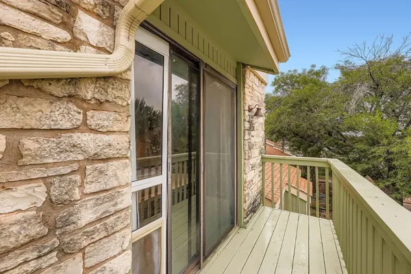a view of a balcony with wooden floor and fence
