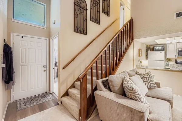 a living room with furniture and a dining table with wooden floor