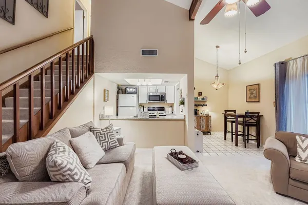 a living room with furniture gym equipment and kitchen view