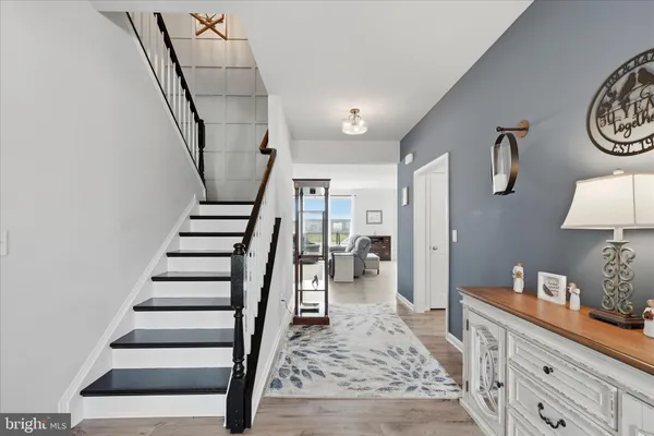 a living room with furniture a dining table and a floor to ceiling window