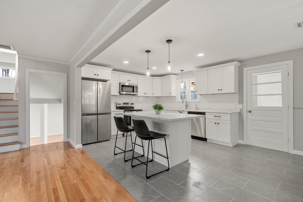 3 Mower Street Paxton, MA 01612 - Photo 20 of 36 a kitchen with stainless steel appliances kitchen island a refrigerator a stove a sink and white cabinets with wooden floor