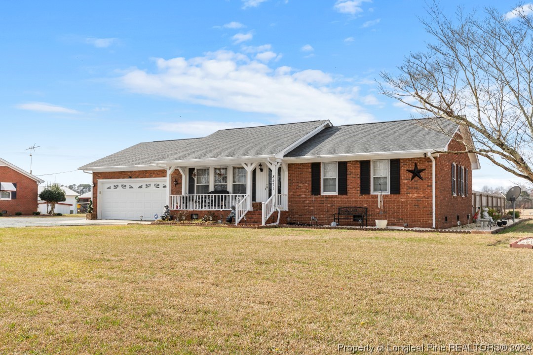 8571 Rhodes Pond Road Dunn, NC 28334 - Photo 4 of 18 a front view of a house with a yard