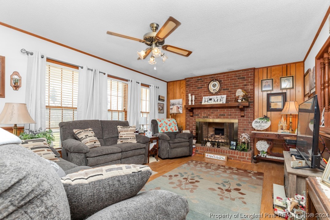 8571 Rhodes Pond Road Dunn, NC 28334 - Photo 6 of 18 a living room with furniture a fireplace and a large window