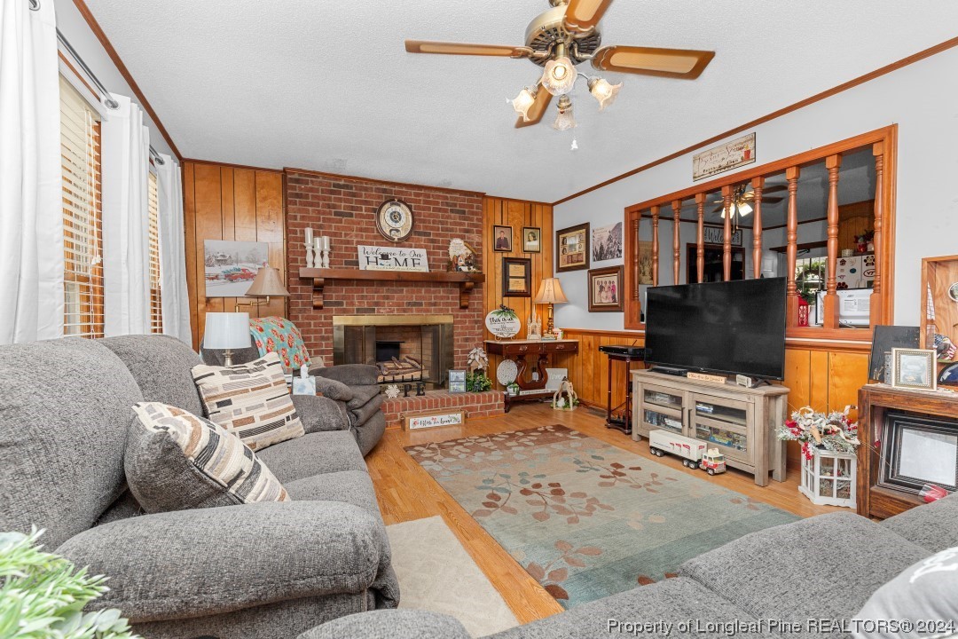 8571 Rhodes Pond Road Dunn, NC 28334 - Photo 7 of 18 a living room with furniture a fireplace and a flat screen tv