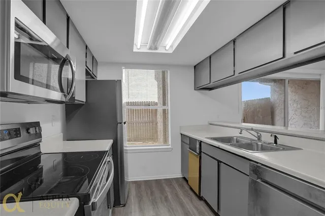 a kitchen with stainless steel appliances granite countertop a sink stove and cabinets