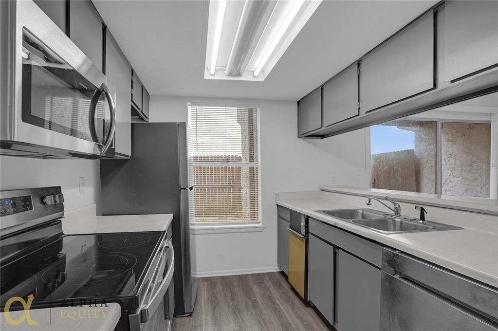 a kitchen with stainless steel appliances granite countertop a sink stove and cabinets