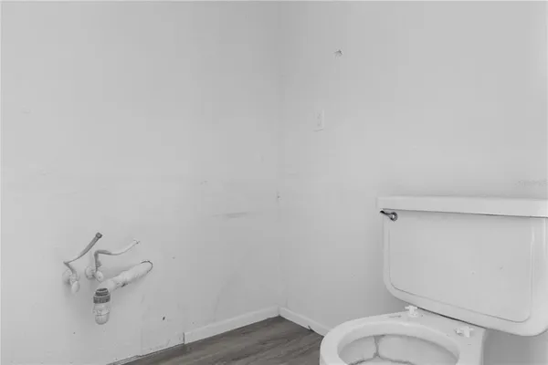 a white toilet sitting next to a white wall