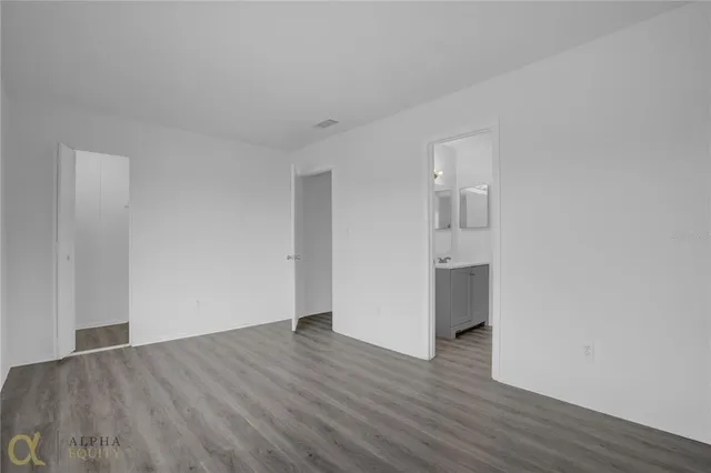 a view of empty room with wooden floor
