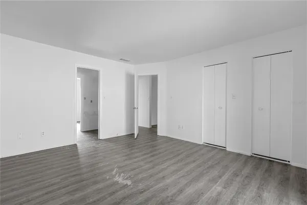 a view of an empty room with wooden floor