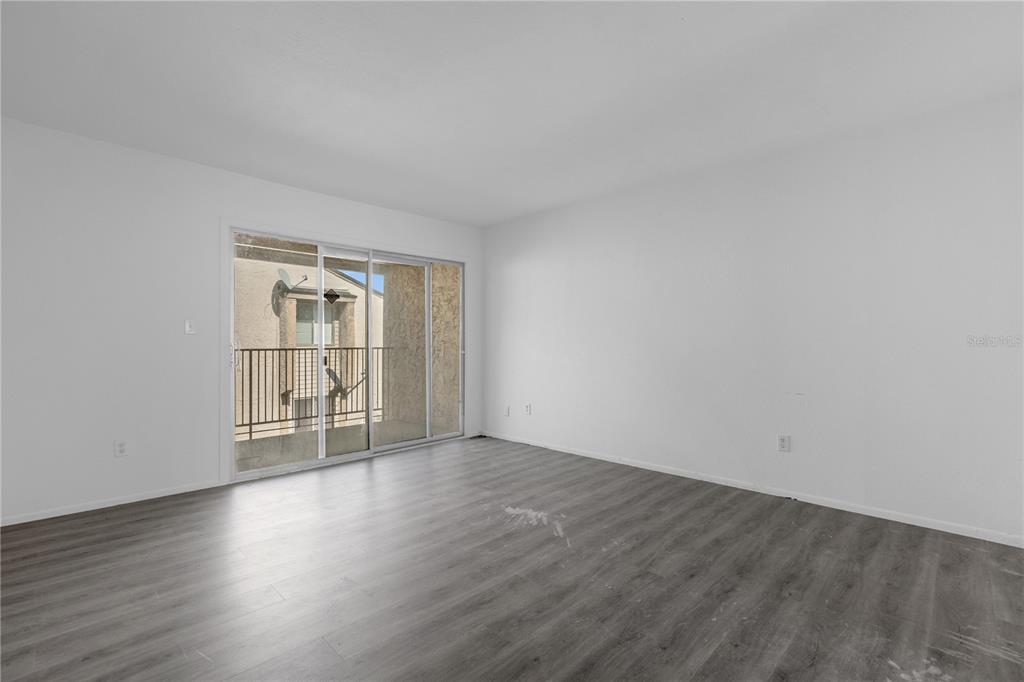 4025 Billingsgate Road, Unit 2004 Orlando, FL 32839 - Photo 20 of 23 an empty room with wooden floor and windows
