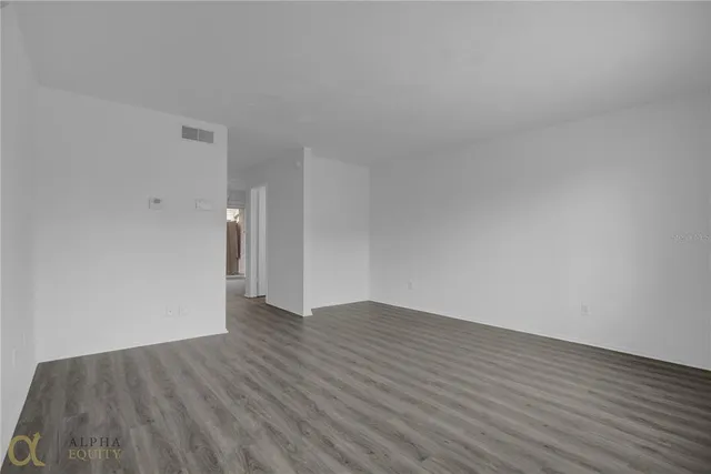 a view of an empty room with wooden floor