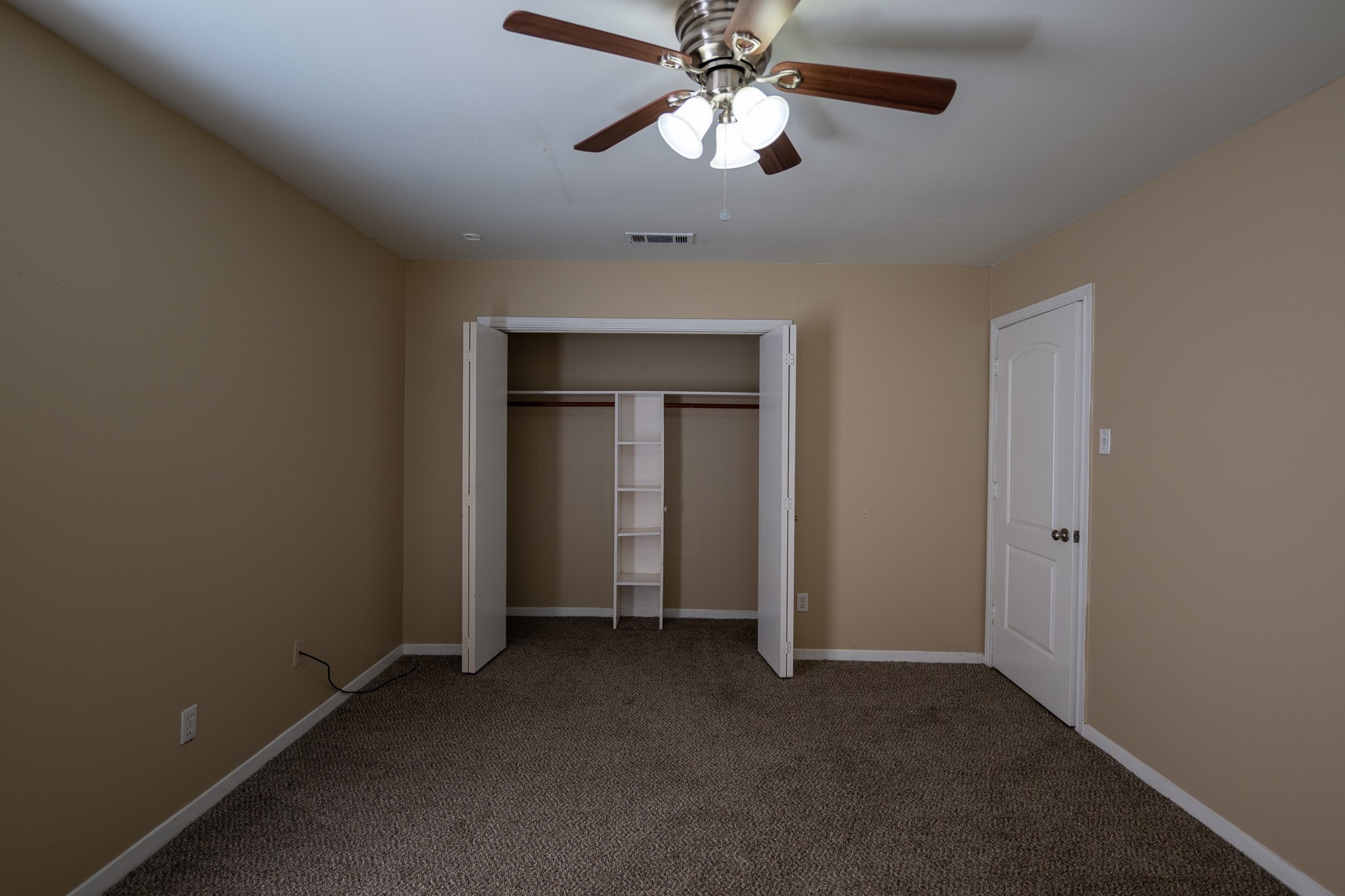 2304 Cedar Bayou Road Baytown, TX 77520 - Photo 10 of 14 an empty room with closet and a chandelier fan
