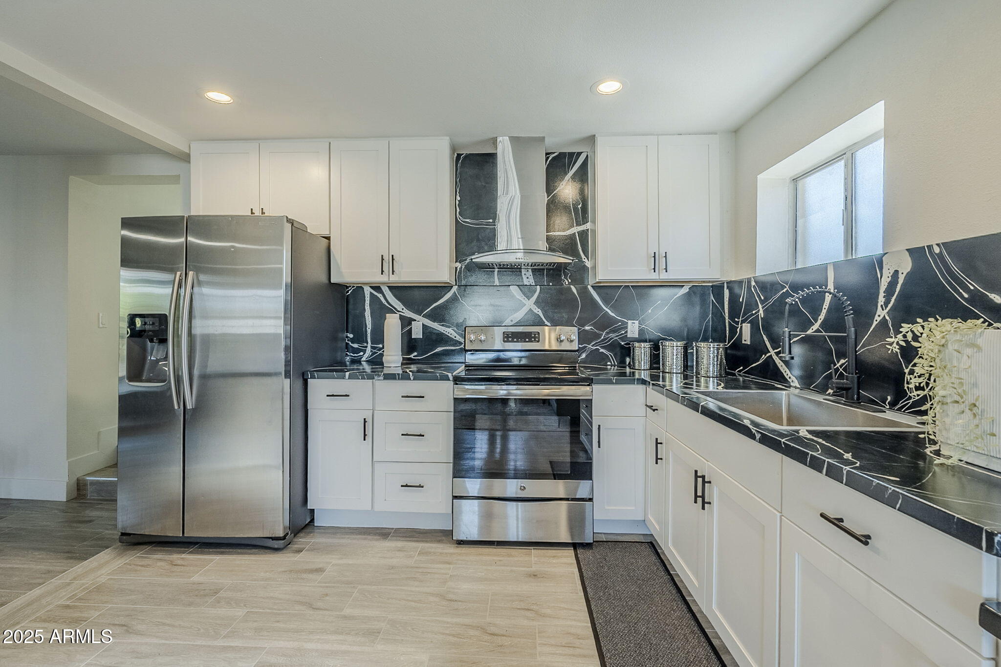 8644 West Mountain View Road Peoria, AZ 85345 - Photo 12 of 35 a kitchen with stainless steel appliances granite countertop a stove a refrigerator and a sink
