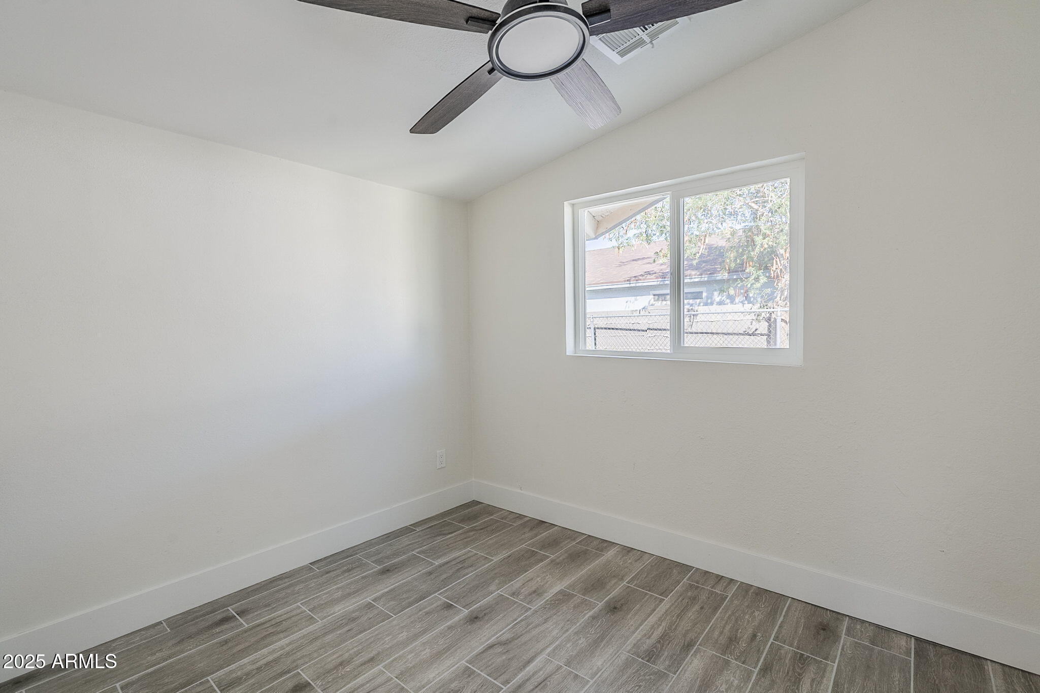 8644 West Mountain View Road Peoria, AZ 85345 - Photo 16 of 35 wooden floor in an empty room with a window