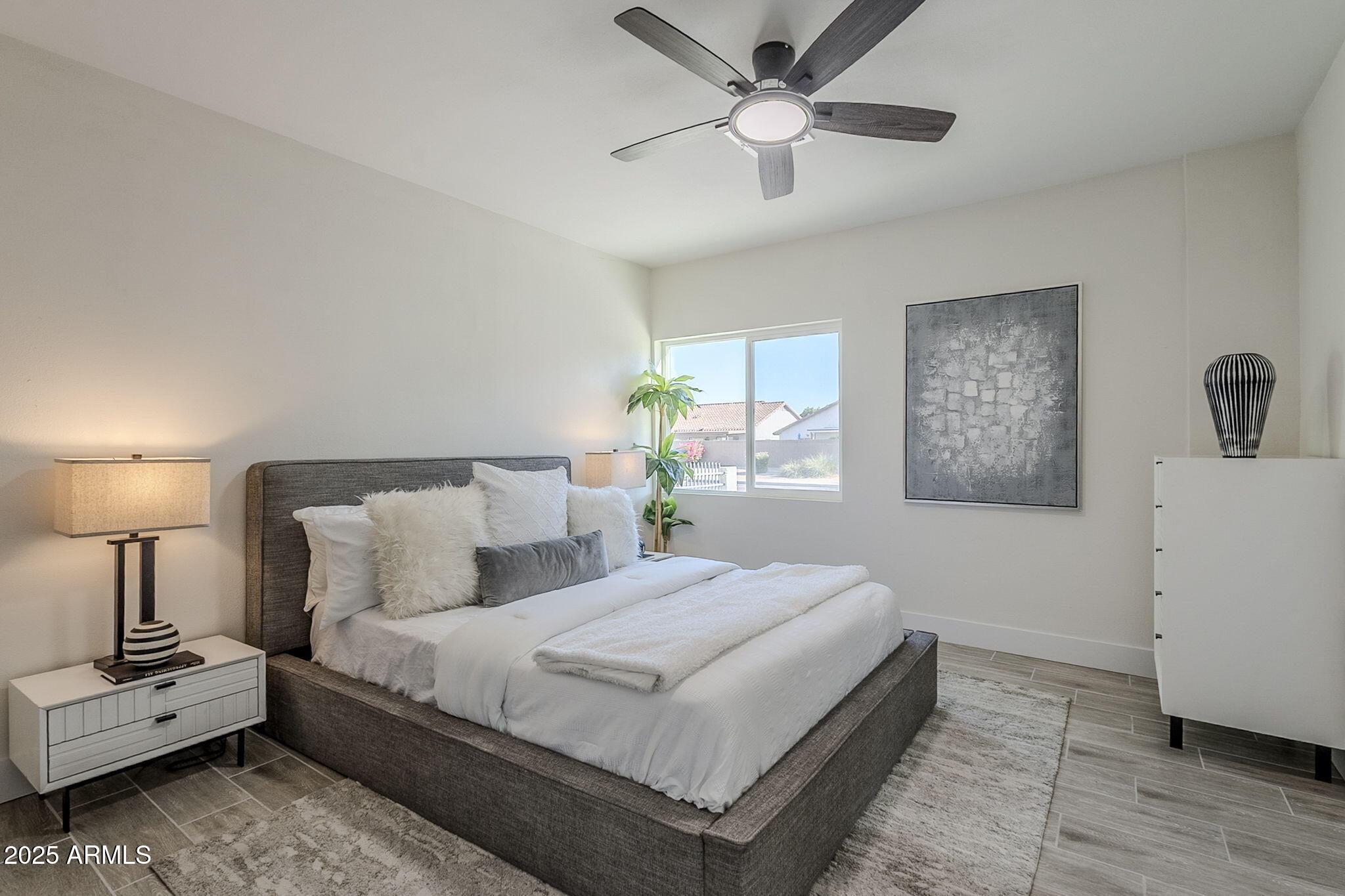 8644 West Mountain View Road Peoria, AZ 85345 - Photo 18 of 35 a bedroom with a large bed and a chandelier