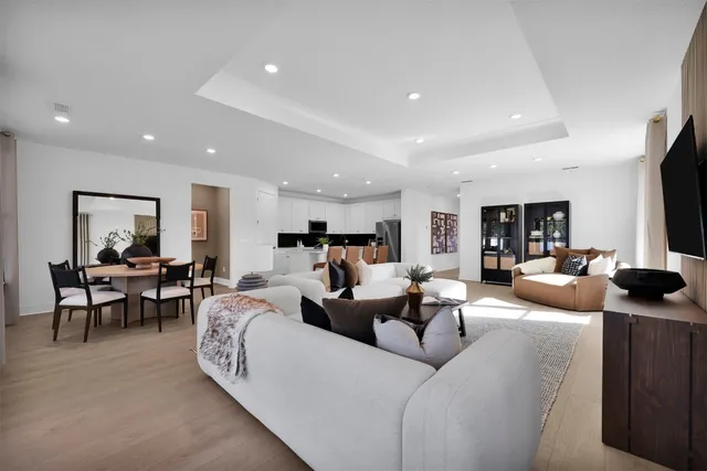 a living room with furniture kitchen view and a flat screen tv