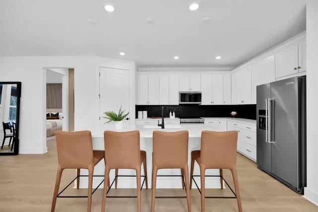 a large kitchen with dining table and chairs