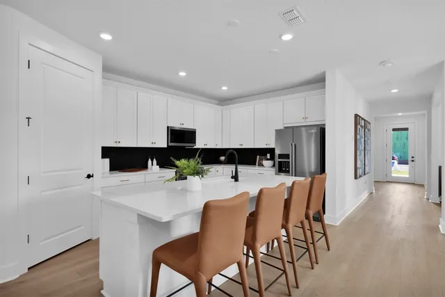 a kitchen with stainless steel appliances kitchen island granite countertop a refrigerator and microwave