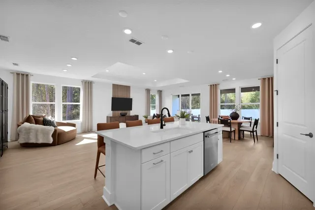 a view of living room kitchen with stainless steel appliances granite countertop furniture and a sink