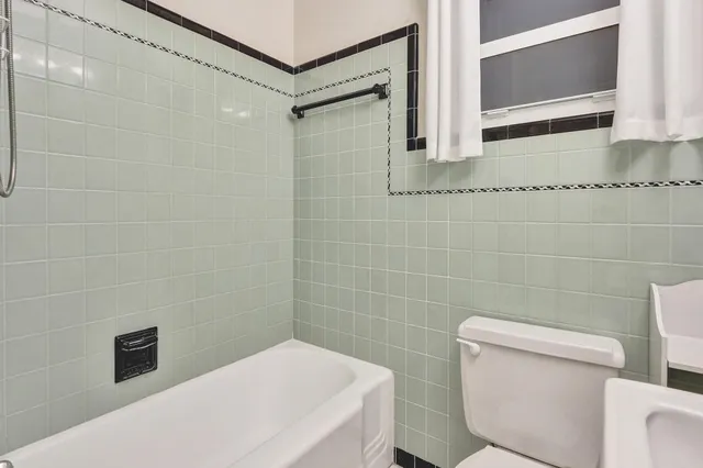 a bathroom with a granite countertop toilet sink and mirror