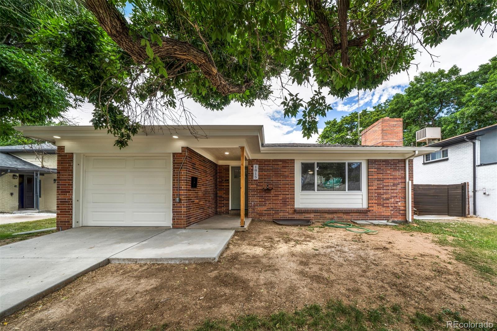 a front view of house with yard and trees in the background