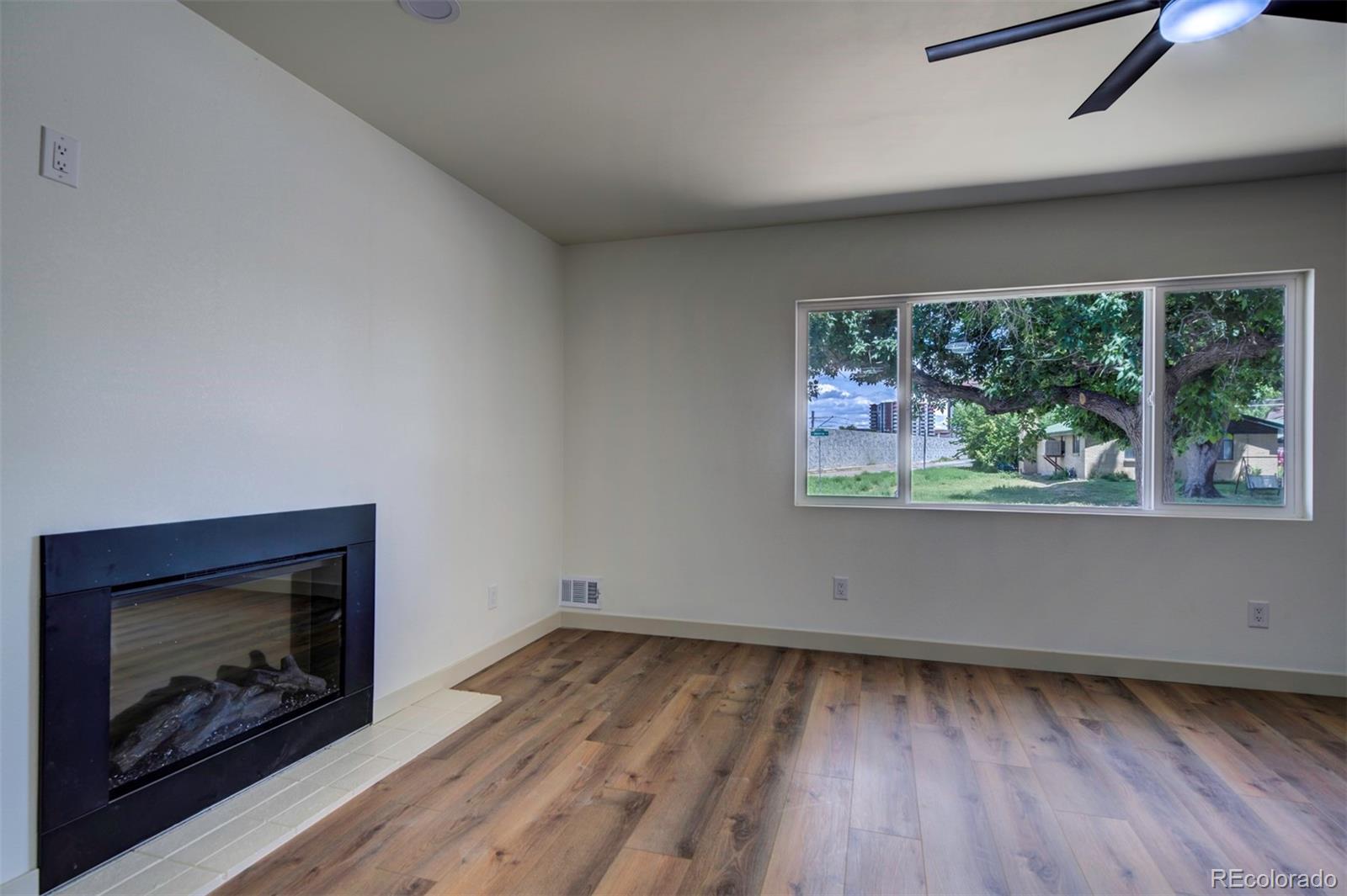 1815 South Monroe Street Denver, CO 80210 - Photo 7 of 37 an empty room with a fireplace and wooden floor