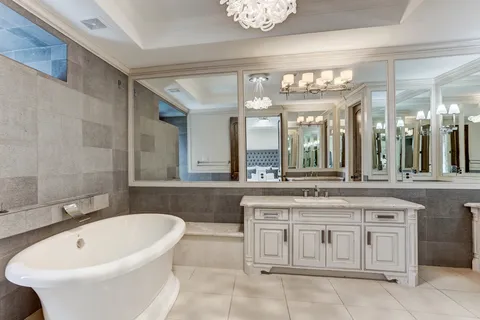a bathroom with a tub sink shower and a mirror