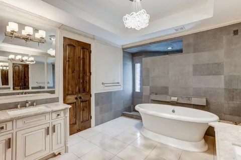 a large white kitchen with a chandelier
