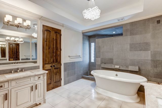 a large white kitchen with a chandelier