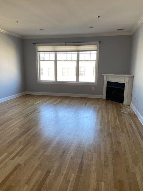 82 Clinton Street, Unit 5E Hoboken, NJ 07030 - Photo 4 of 7 an empty room with wooden floor and windows
