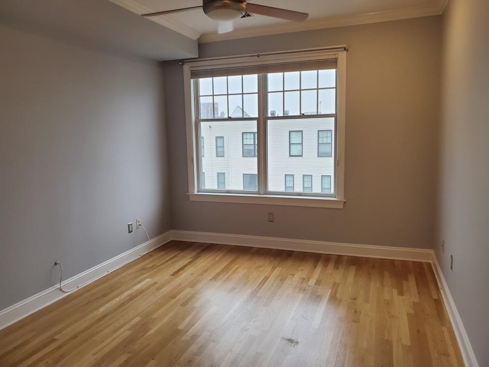 82 Clinton Street, Unit 5E Hoboken, NJ 07030 - Photo 6 of 7 a view of an empty room with wooden floor and a window