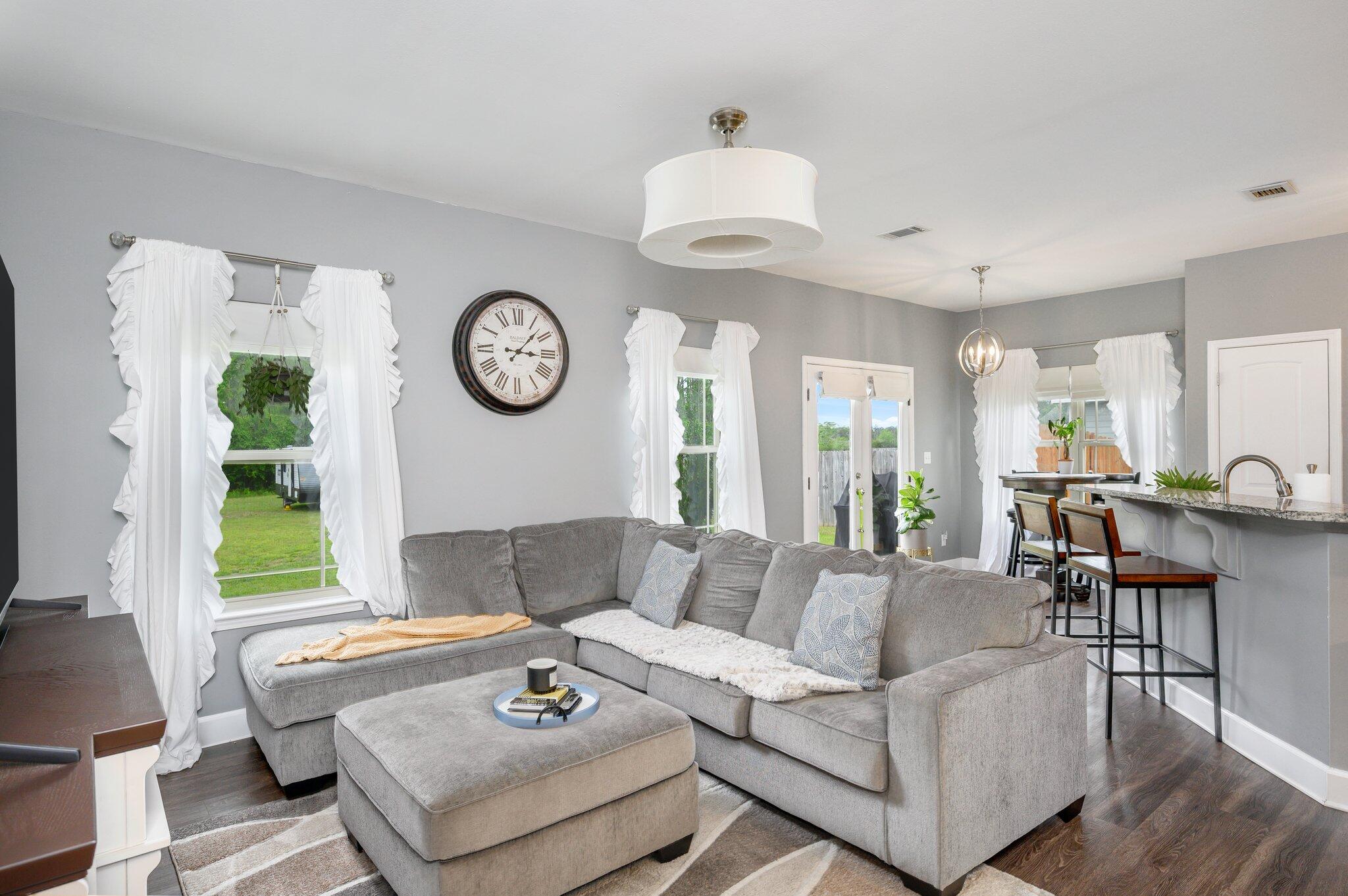 5620 Price Plantation Road Baker, FL 32531 - Photo 14 of 37 a living room with furniture a clock and a large window