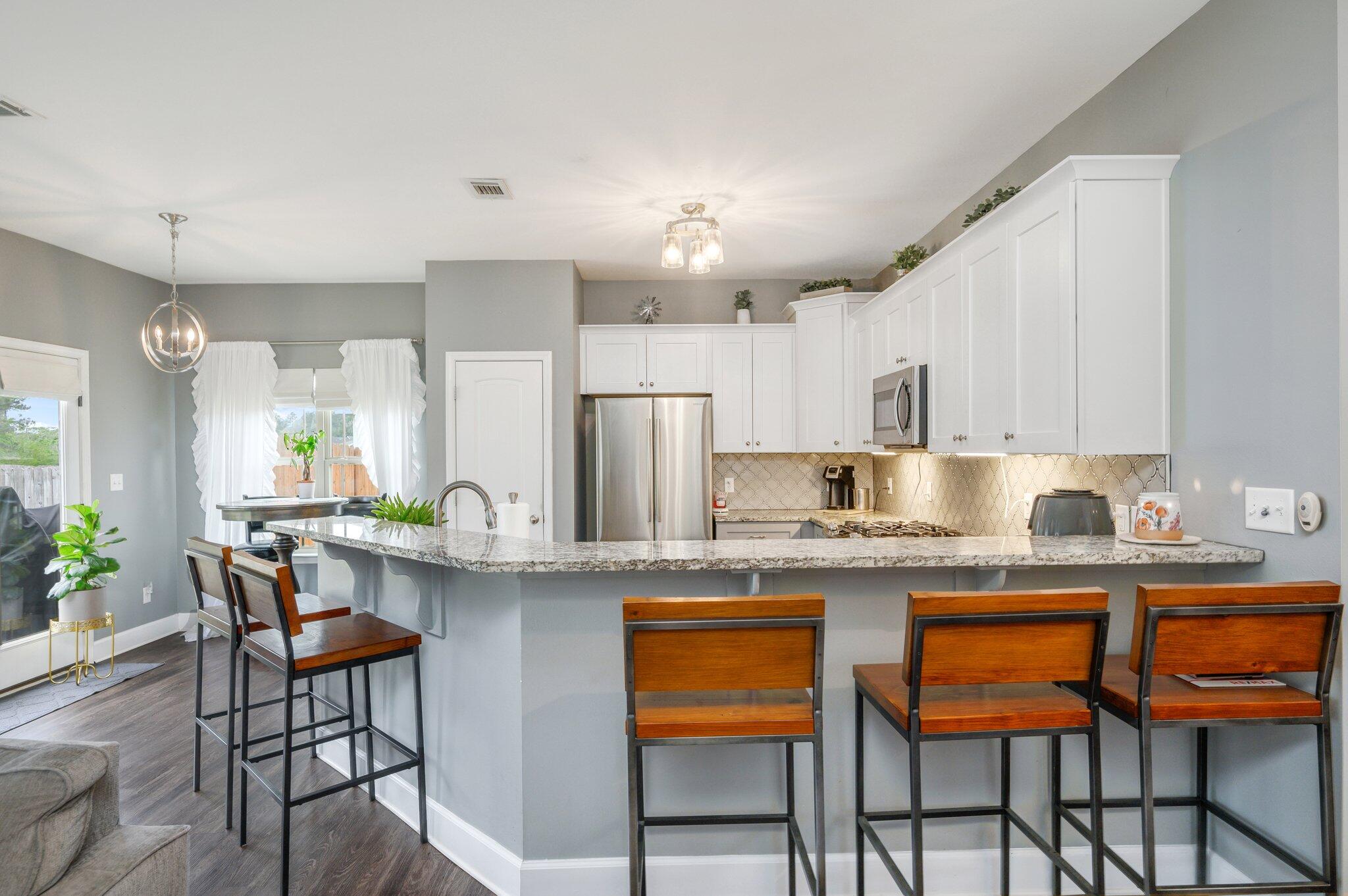 5620 Price Plantation Road Baker, FL 32531 - Photo 16 of 37 a kitchen with stainless steel appliances kitchen island granite countertop a table chairs sink and cabinets
