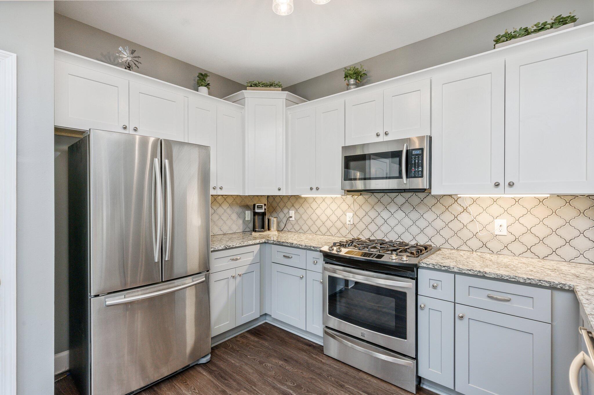 5620 Price Plantation Road Baker, FL 32531 - Photo 23 of 37 a kitchen with cabinets stainless steel appliances and wooden floor