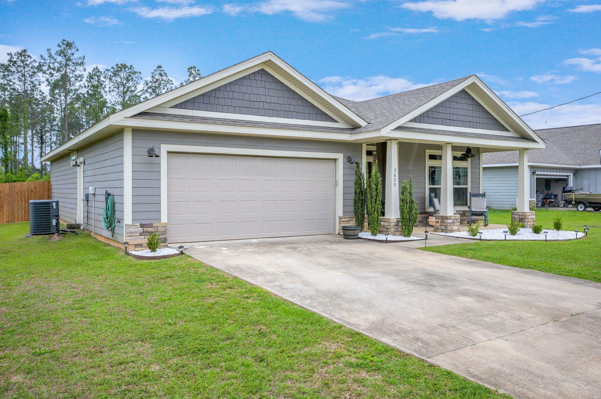 5620 Price Plantation Road Baker, FL 32531 - Photo 3 of 37 a front view of a house with a yard and garage