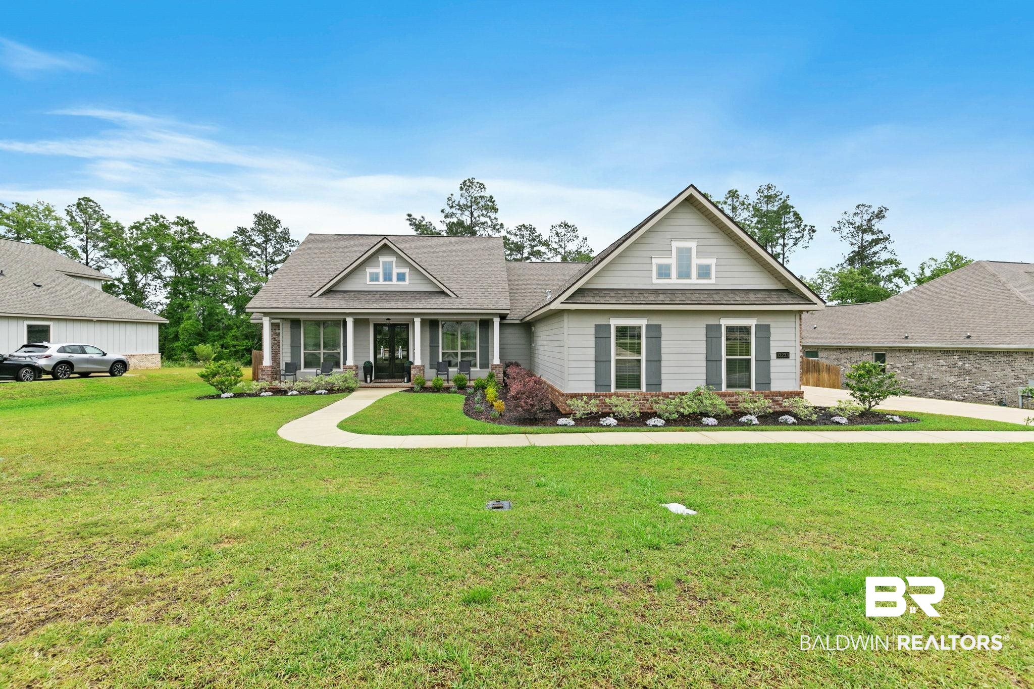 13233 Ibis Boulevard Daphne, AL 36527 - Photo 67 of 100 Craftsman-style home featuring a covered front porch with columns, light gray siding, dark shutters, and a prominent front gable