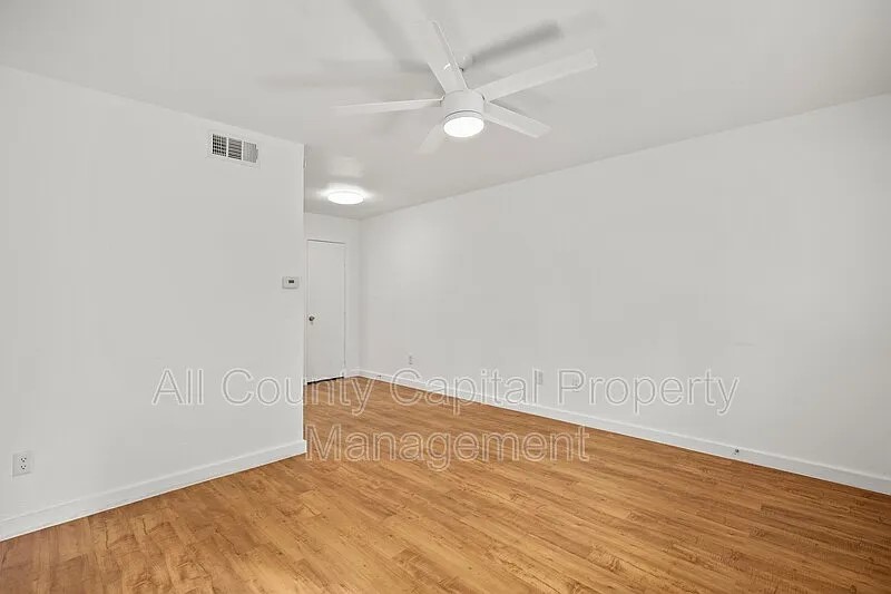 404 West 35th Street, Unit 101 Austin, TX 78705 - Photo 3 of 10 an empty room with wooden floor and fan