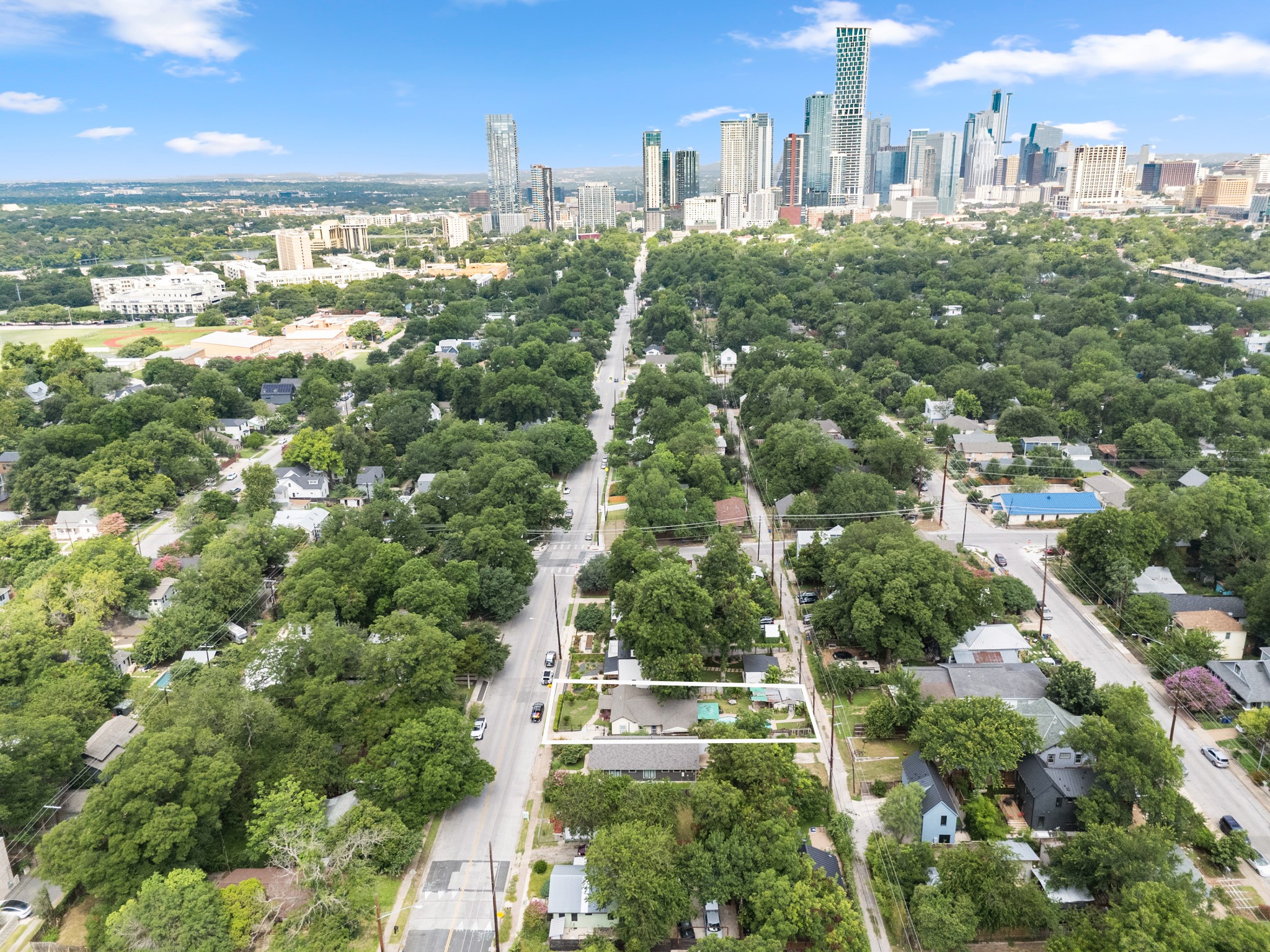 1908 Holly Street Austin, TX 78702 - Photo 18 of 22 An aerial perspective reveals a tree-lined neighborhood leading to a vibrant urban skyline.