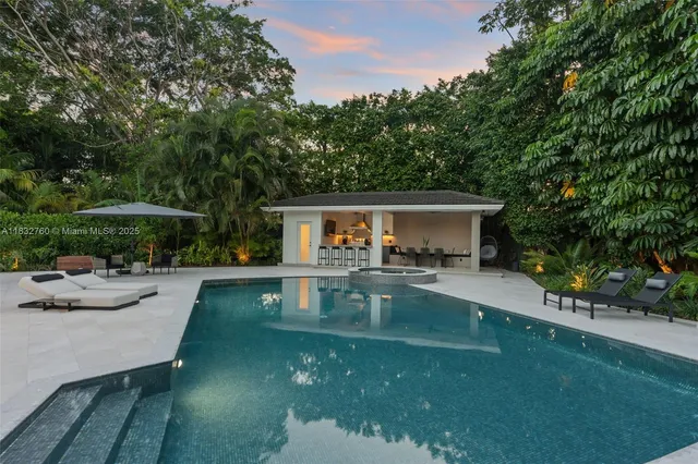 a kitchen with a dining table chairs and white cabinets
