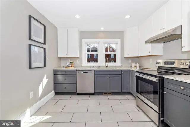 a kitchen with a stove sink and cabinets