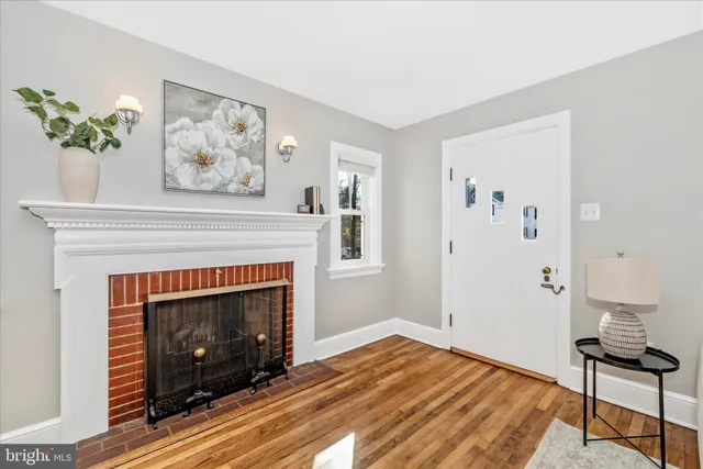 a living room with a fireplace and wooden floor