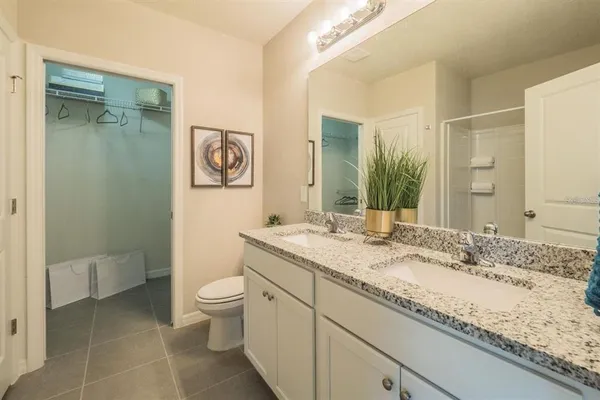a bathroom with a granite countertop sink a toilet and a mirror
