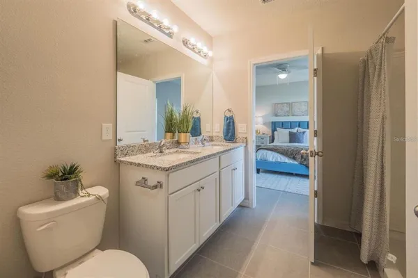 a bathroom with a granite countertop sink mirror and toilet