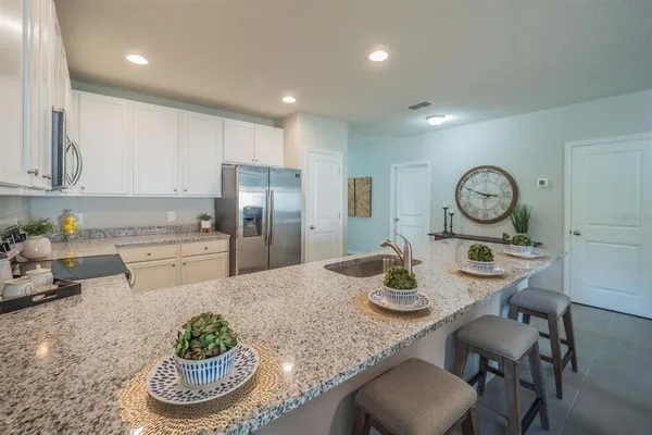 a kitchen with granite countertop a table and chairs