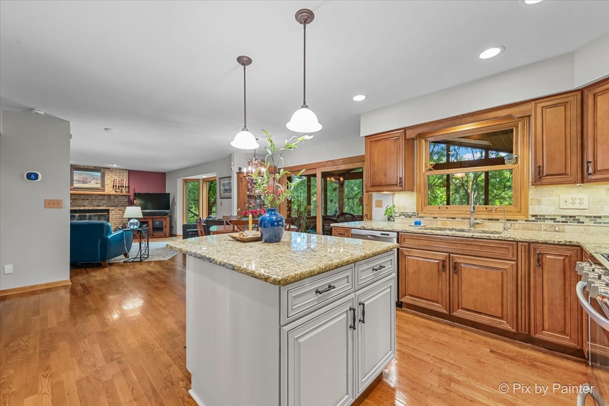 28971 Fox Street Cary, IL 60013 - Photo 12 of 51 a kitchen with stainless steel appliances granite countertop a sink a stove and a wooden floors