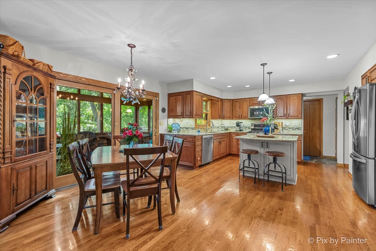 28971 Fox Street Cary, IL 60013 - Photo 13 of 51 a view of a dining room and livingroom with furniture wooden floor a chandelier