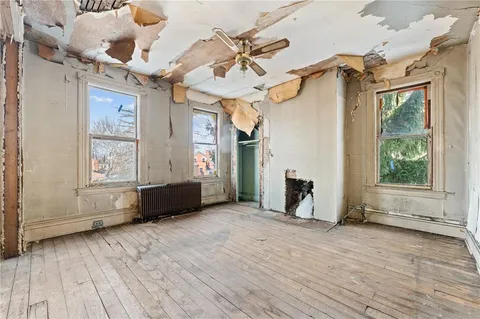 a view of a room with wooden floor and white walls