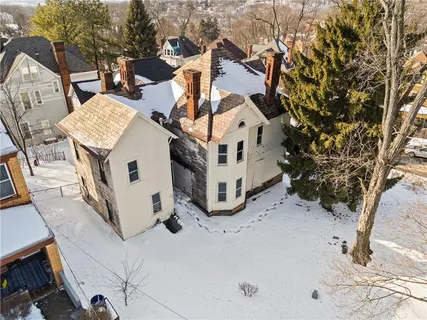 a view of a house with backyard and trees